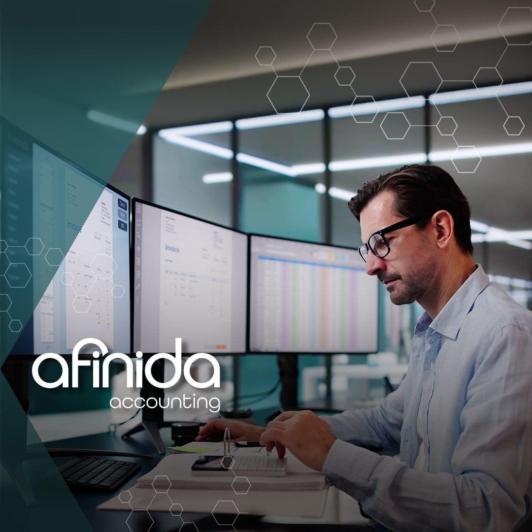 Professional accountant analyzing financial data on multiple screens in a modern office, representing Afinida’s new fractional CFO services for growing businesses.
